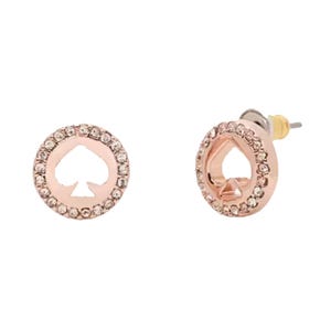 A pair of round, rose gold-tone earrings with a spade symbol at the center, surrounded by small crystals.