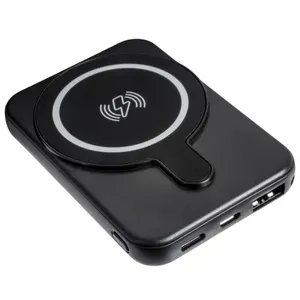 A black wireless power bank with a circular charging pad and multiple input/output ports for charging devices.