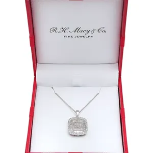 A silver necklace with a rectangular pendant featuring intricate diamond detailing is displayed in an open red jewelry box labeled \“R.H. Macy & Co. Fine Jewelry.\“