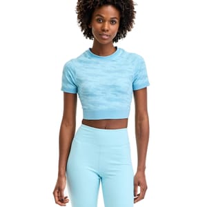 A person wearing a light blue, short-sleeve, cropped athletic top with a subtle camouflage pattern and matching high-waisted leggings.