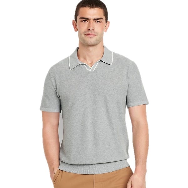 A man is wearing a light gray short-sleeve knit polo shirt with a white-trimmed collar and camel-colored pants.