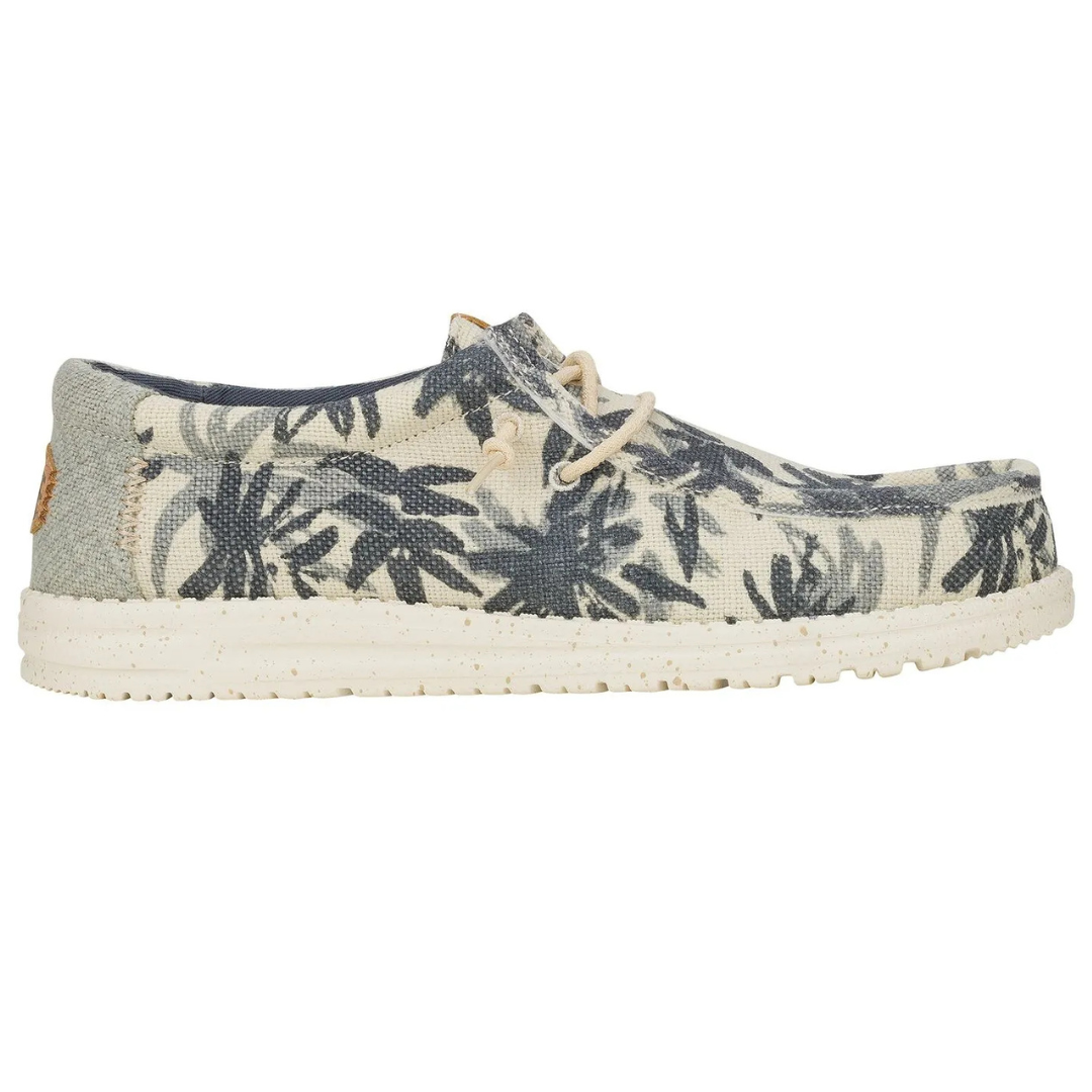 Canvas slip-on shoe with a tropical leaf pattern, featuring a speckled white sole and beige laces.