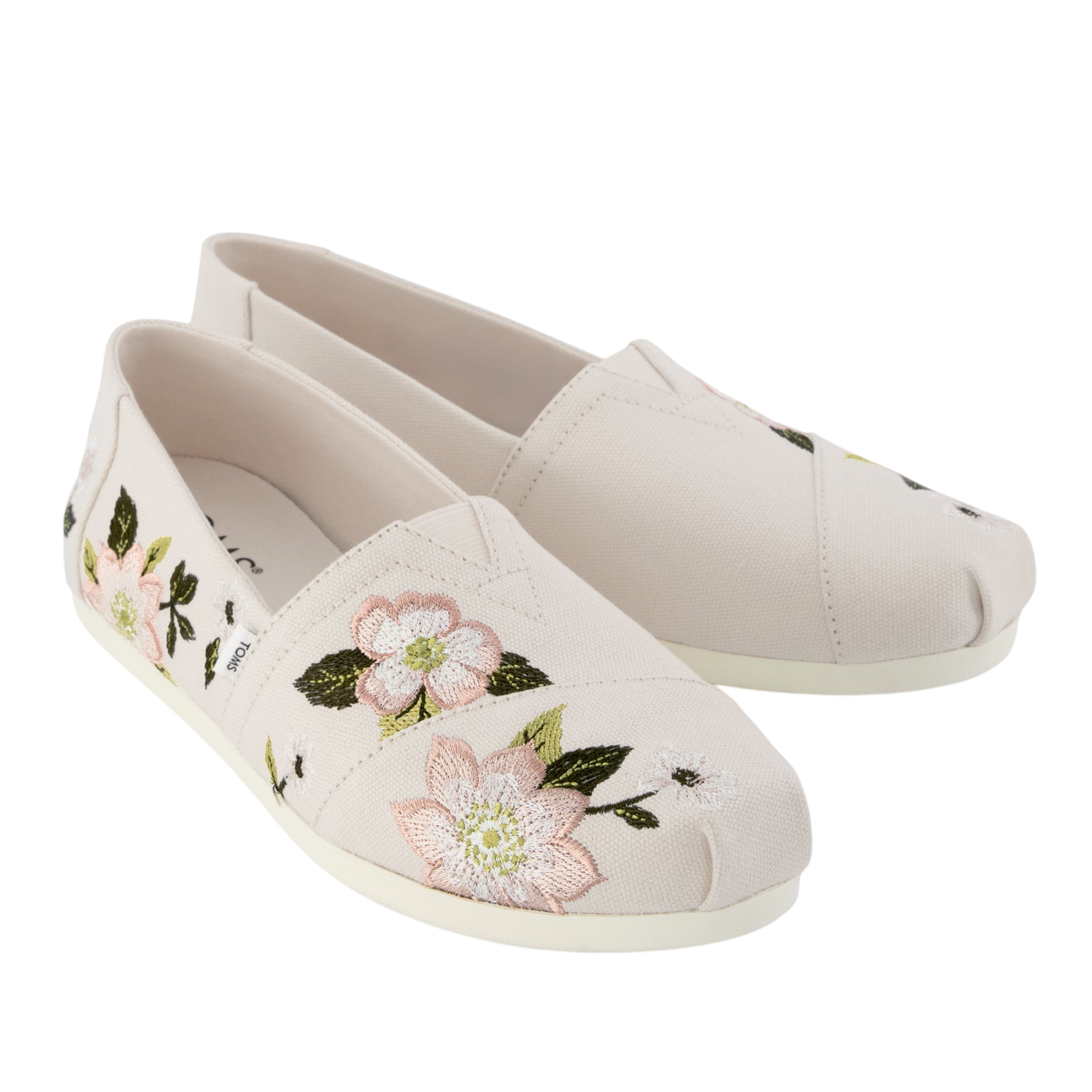 Cream-colored slip-on shoes with floral embroidery featuring pink flowers and green leaves.