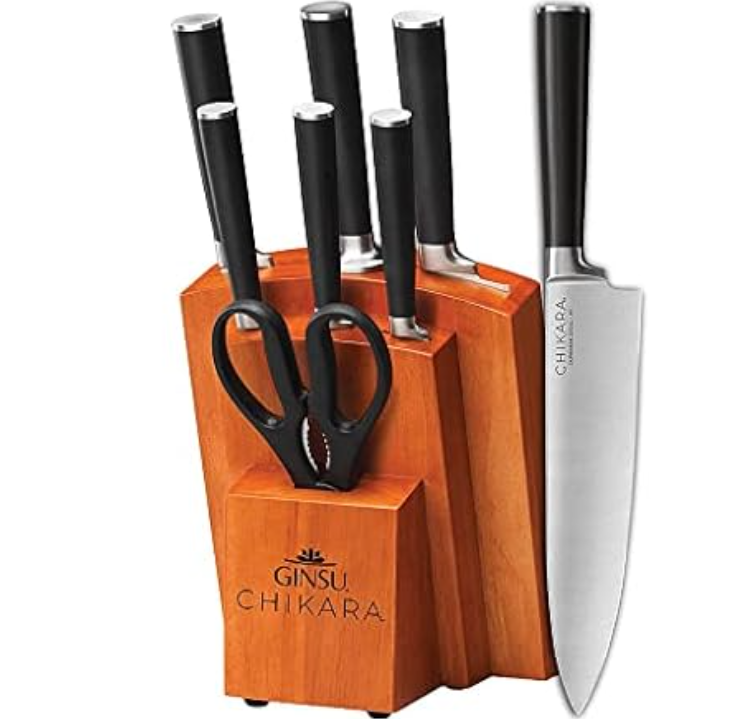 A Ginsu Chikara knife set with a wooden block, including various knives and kitchen scissors, featuring black handles and a stainless steel finish.
