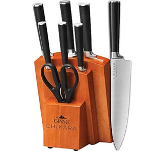 A Ginsu Chikara knife set with a wooden block, including various knives and kitchen scissors, featuring black handles and a stainless steel finish.