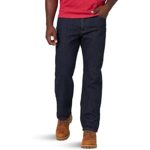 Rustler Men's Jeans are straight-leg, dark blue denim jeans, paired with brown work boots and a red shirt. They feature a classic, functional design with a traditional fit.