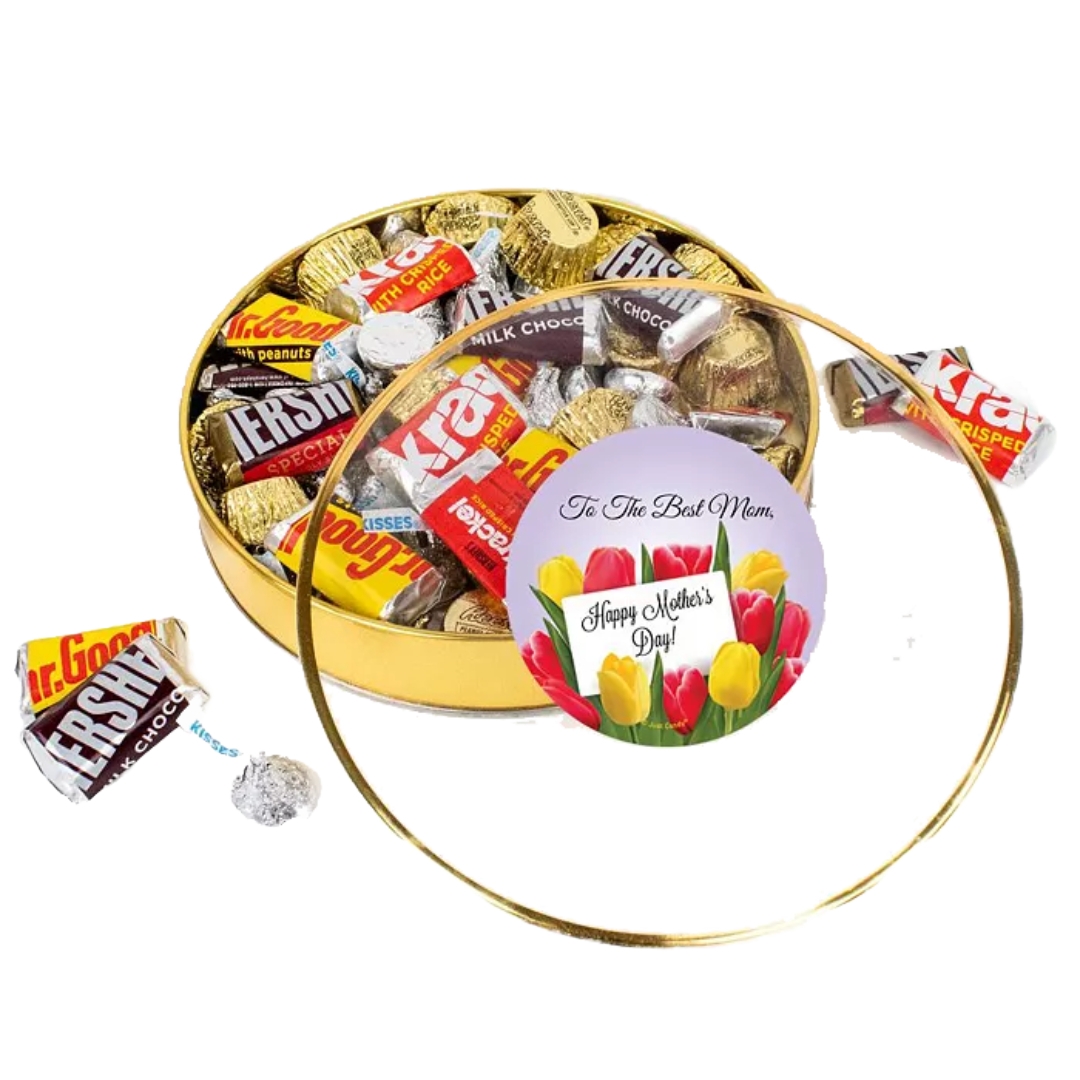 A round gold tin filled with assorted chocolates, including Hershey's, Krackel, Mr. Goodbar, and Reese's, with a \“Happy Mother's Day\“ floral card on the lid.