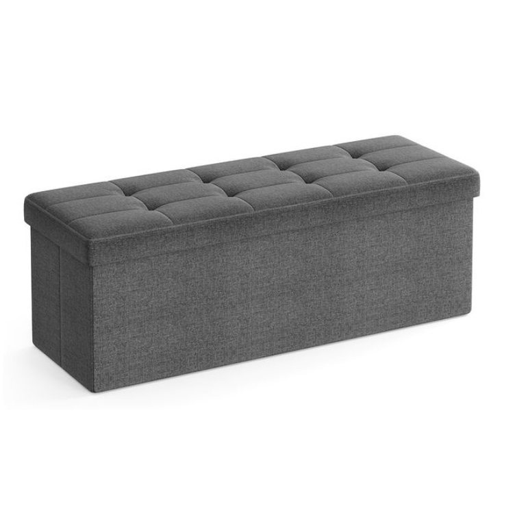 A gray upholstered storage ottoman bench with a tufted lid, designed for seating and storage.
