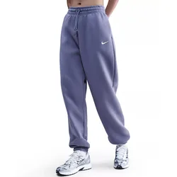 A person is wearing light purple Nike sweatpants with a small white swoosh logo, paired with silver and white Nike sneakers.