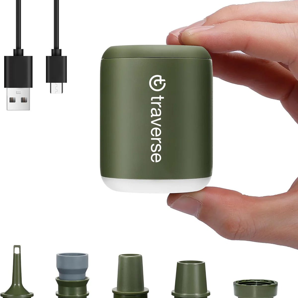 Portable green charger with various USB connectors and interchangeable plug heads held between fingers.