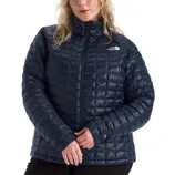 A woman wearing a navy quilted puffer jacket from The North Face, featuring a high collar and front zipper closure.