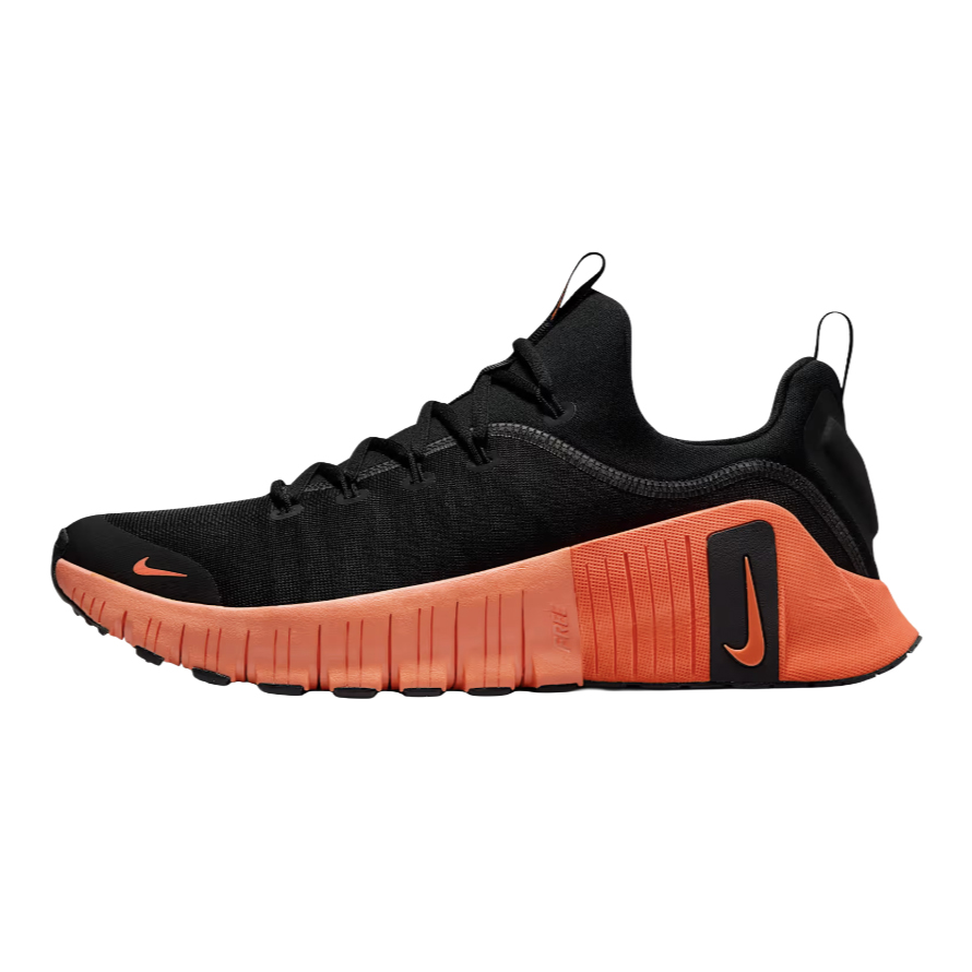 A black and bright orange athletic shoe with a low-cut design, featuring a prominent swoosh logo and flexible segmented sole for enhanced movement.