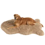 A golden retriever is lying on a beige, bone-shaped, fluffy dog bed, providing a soft and cozy resting place.