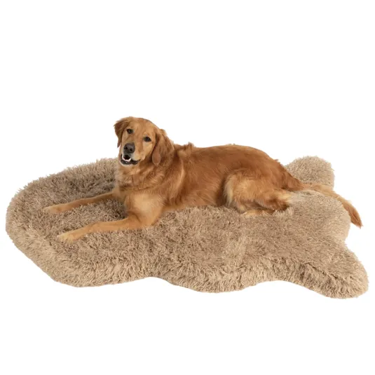 A golden retriever is lying on a beige, bone-shaped, fluffy dog bed, providing a soft and cozy resting place.