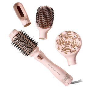 The 4pc Beachwaver Blow Brush set includes a pink handle with interchangeable attachments: a round brush, paddle brush, diffuser, and concentrator nozzle for versatile hair styling.