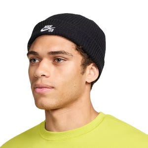 A person wearing a black Nike SB beanie and a lime green shirt.