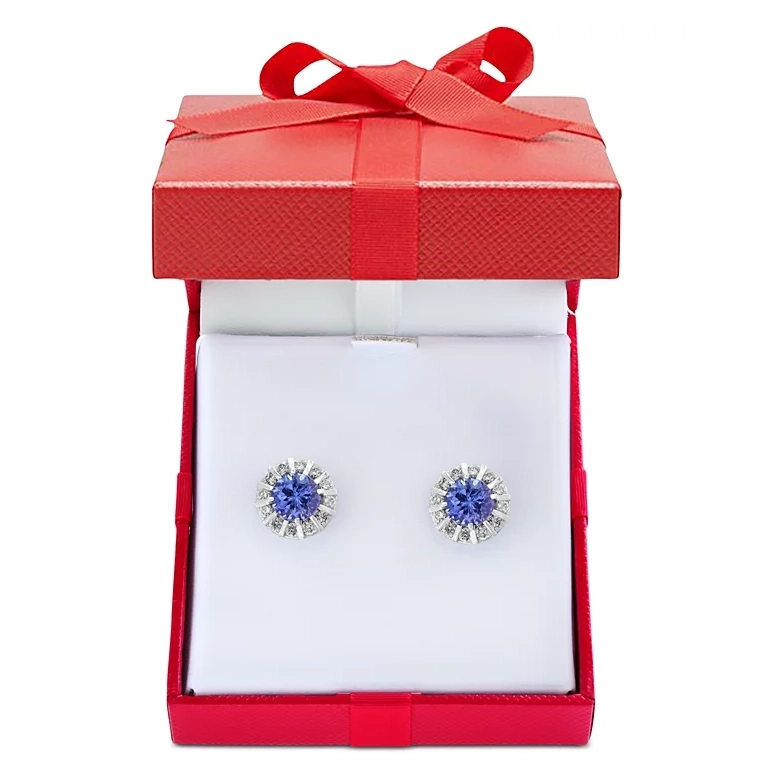 Earrings with a central tanzanite gemstone encircled by a halo of diamonds, presented in a red gift box with a ribbon.