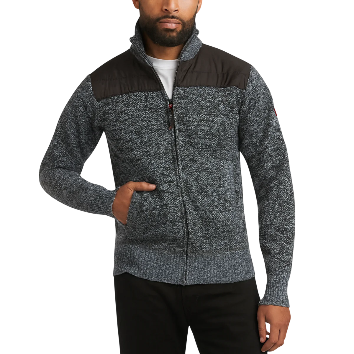 A man is wearing a gray textured sweater with a front zipper and black quilted shoulder panels, paired with black pants.