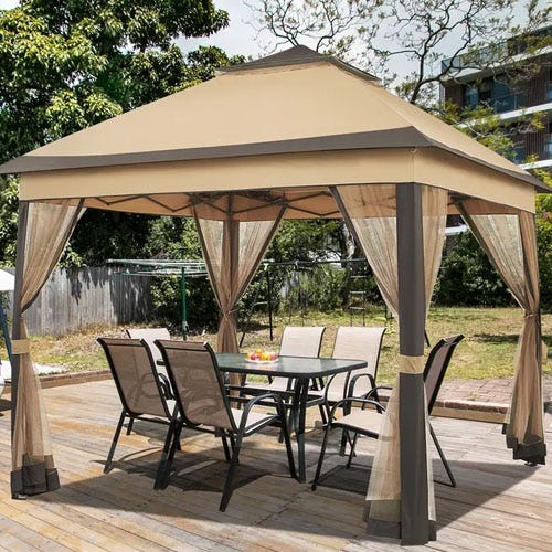 A gazebo with a beige canopy is shown on a wooden deck, featuring mesh curtains and a glass dining table with six chairs underneath.