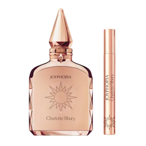 Charlotte Tilbury Joyphoria perfume and lip gloss set, featuring a rose gold perfume bottle and a matching lip gloss tube, both adorned with sunburst designs.