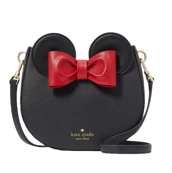 A black Kate Spade crossbody bag featuring a design inspired by a popular character with mouse ears and a prominent red bow.