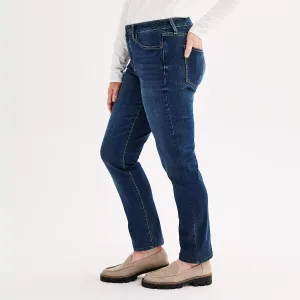 A person wearing dark blue jeans and beige loafers.