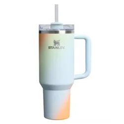 A Stanley tumbler with a gradient design featuring hues of blue, orange, and yellow, equipped with a handle, lid, and straw.