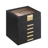 A black jewelry box with gold handles features a glass top displaying compartments for rings and other items.