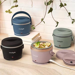 Four portable Crockpot food warmers, in a variety of colors, displayed on a countertop.