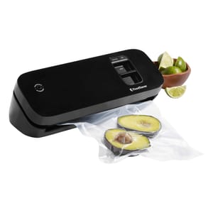 A FoodSaver vacuum sealer beside a sealed bag with avocado halves and a bowl with limes.