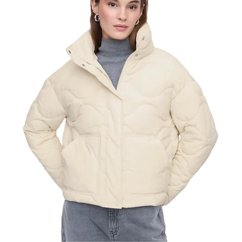 A cream-colored quilted nylon jacket with a high collar, front pockets, and a subtle wave pattern, worn over a gray turtleneck.
