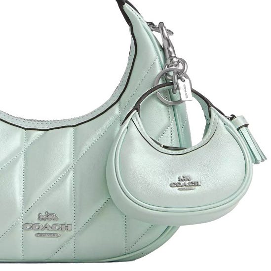 A mint green Coach shoulder bag with diamond quilting is accompanied by a matching mini bag keychain.