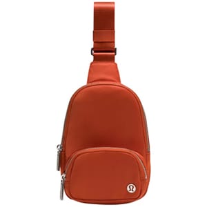Orange Lululemon sling bag with front zip pocket and adjustable strap.