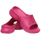 A pair of bright pink Crocs slip-on sandals with ventilation holes and a slightly elevated sole, designed for casual wear.