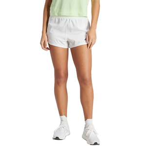 A person is wearing light gray athletic shorts with an elastic waistband and a small logo on the left leg, paired with white running shoes and a mint green top.