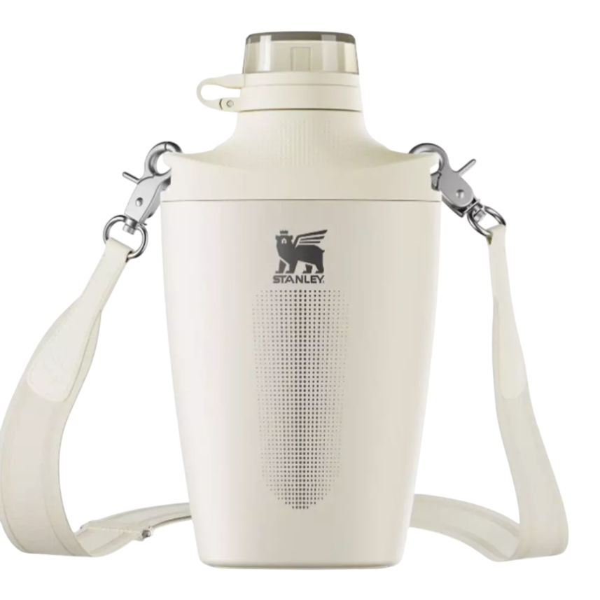 A cream-colored Stanley insulated jug with a shoulder strap and a secure top lid, featuring a carrying strap and metal clasps.