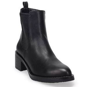 A black leather Chelsea boot featuring a low stacked heel, elastic side panels for a snug fit, and a pull-tab at the back for easy on and off.