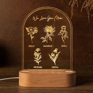 Custom night light with a wooden base and acrylic plaque featuring the engraved message \“We Love You Mom\“ above five illustrated flowers, each with a name: Kelly, Madison, Sofia, Michael, and Olivia.