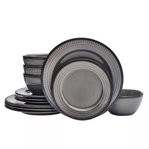 A set of ceramic dinnerware with a gray, patterned design, including plates and bowls stacked together.