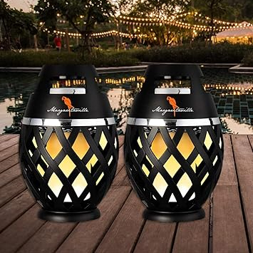 Two decorative outdoor LED torches on a wooden deck with warm yellow lighting and cut-out patterns.