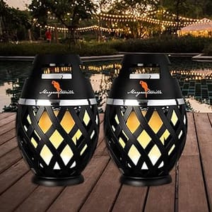 Two decorative outdoor LED torches on a wooden deck with warm yellow lighting and cut-out patterns.