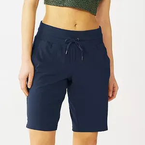 Navy Bermuda shorts featuring a drawstring waist, side pockets, and a mid-thigh length cut.