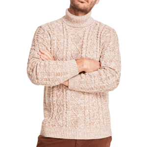 A man is wearing a beige cable-knit turtleneck sweater with a textured pattern and long sleeves, paired with brown pants.