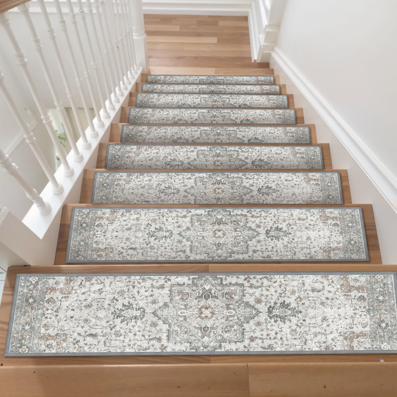 Staircase with patterned carpet treads featuring intricate, traditional designs in muted colors. White balusters and light wood steps complement the decor.