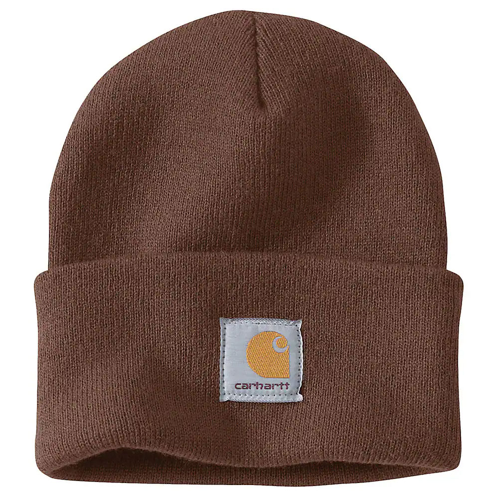 Brown Carhartt winter beanie with a folded cuff featuring a sewn-on square white patch displaying the Carhartt logo in orange. Made of soft, knit material for warmth.