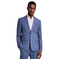 A man in a light blue suit with a two-button jacket, enhanced by a subtle pink and white striped shirt and a pocket square.