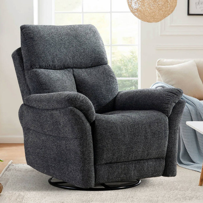 A dark gray, plush reclining chair with a swivel base, set in a cozy living room with natural light streaming through a window.