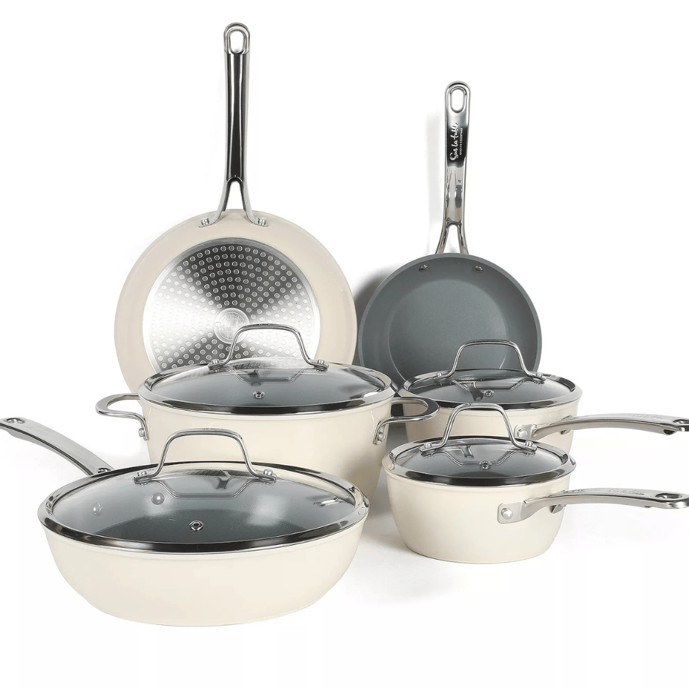 A set of cream-colored non-stick cookware with stainless steel handles, featuring multiple pots and pans with matching lids, designed for versatile cooking needs.
