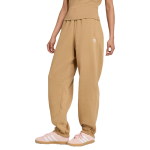 Tan wide-leg sweatpants with an Adidas logo, paired with light pink Adidas sneakers featuring white stripes.