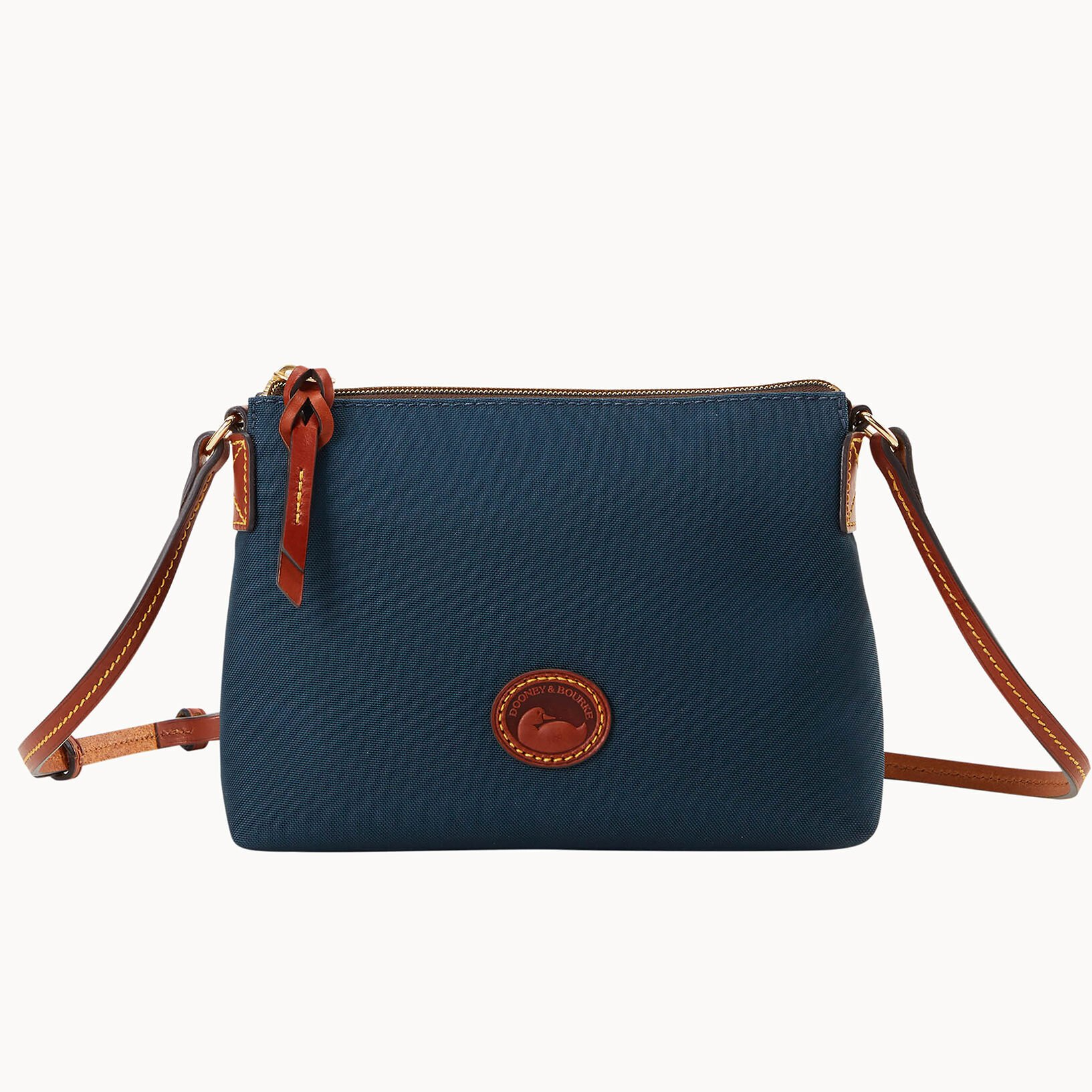 A blue crossbody bag with a brown leather strap and a circular logo on the front.